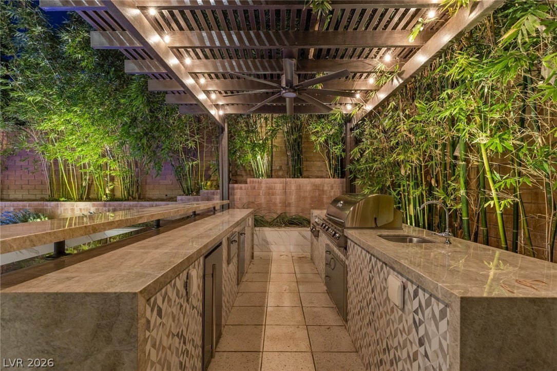 11453 Rhodolite Court, Las Vegas, NV 89135 An outdoor kitchen features tiled counters beneath a handsome wood pergola.
