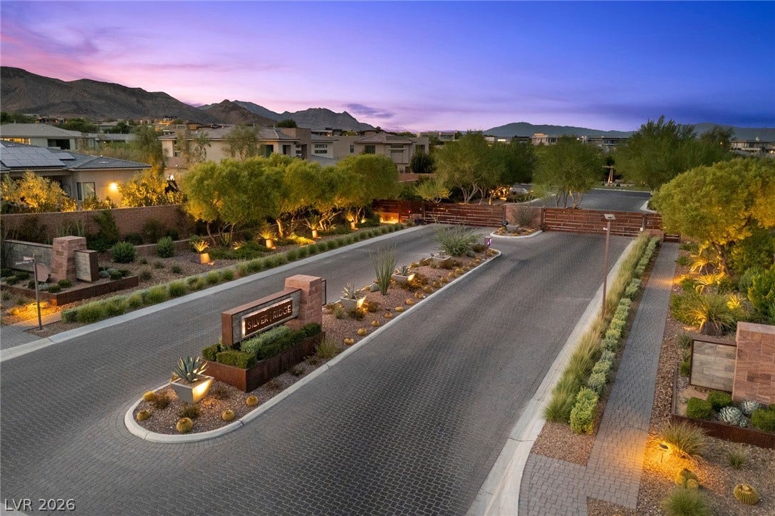11453 Rhodolite Court, Las Vegas, NV 89135 An illuminated gated entrance leads into this neighborhood set against a mountain backdrop.