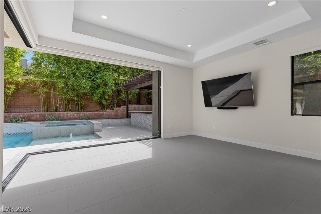 11453 Rhodolite Court, Las Vegas, NV 89135 Massive sliding doors bridge the interior tile flooring with a private backyard pool oasis.