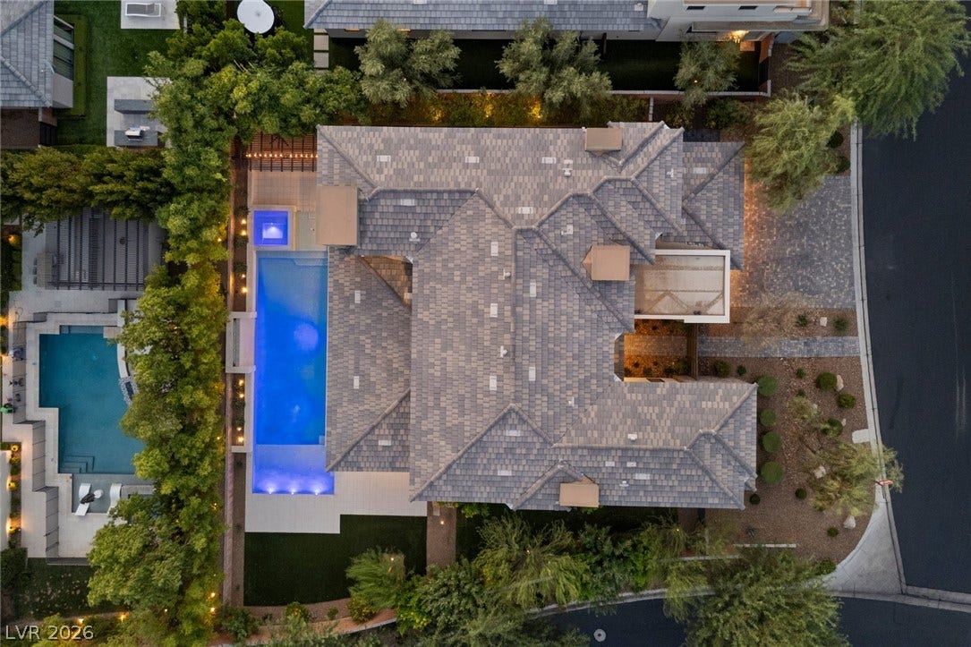 11453 Rhodolite Court, Las Vegas, NV 89135 An aerial perspective reveals a beautifully integrated swimming pool alongside meticulous landscaping and modern tile roofing.
