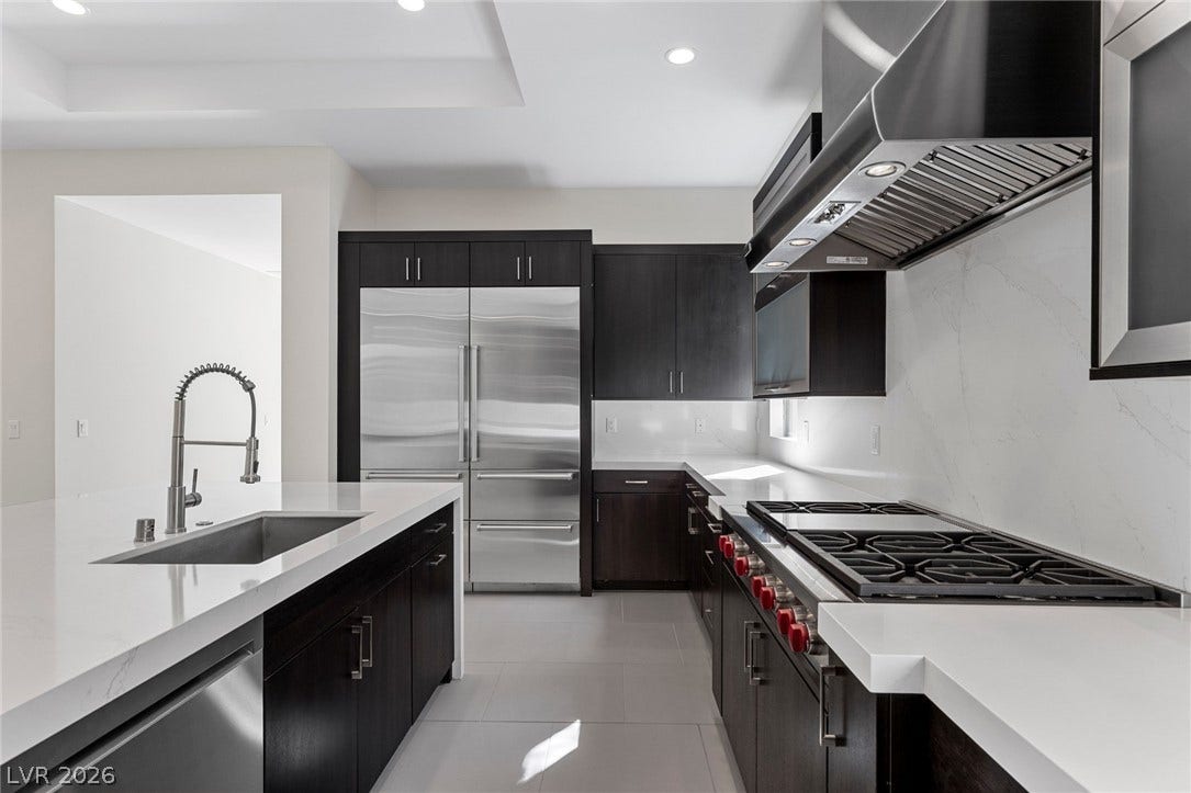 11453 Rhodolite Court, Las Vegas, NV 89135 Sleek dark cabinetry and stone countertops anchor this modern culinary workspace with premium built-in appliances.