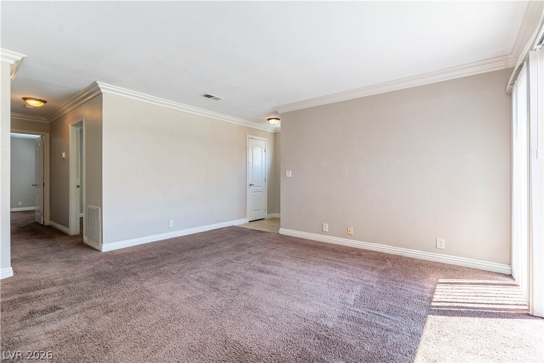 4050 Pacific Harbors Drive, #203, Las Vegas, NV 89121 Plush carpeting and elegant crown molding define this open, light-filled interior space.