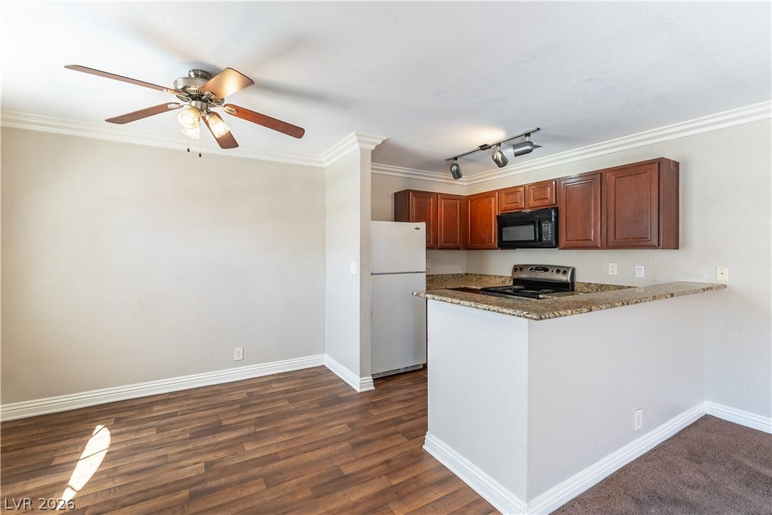 4050 Pacific Harbors Drive, #203, Las Vegas, NV 89121 A peninsula breakfast bar and granite countertops open directly to the adjacent dining space.