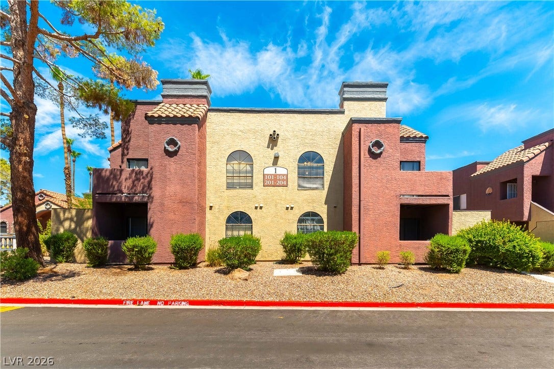 4050 Pacific Harbors Drive, #203, Las Vegas, NV 89121 Stucco exteriors and arched windows define this multi-level residential structure.