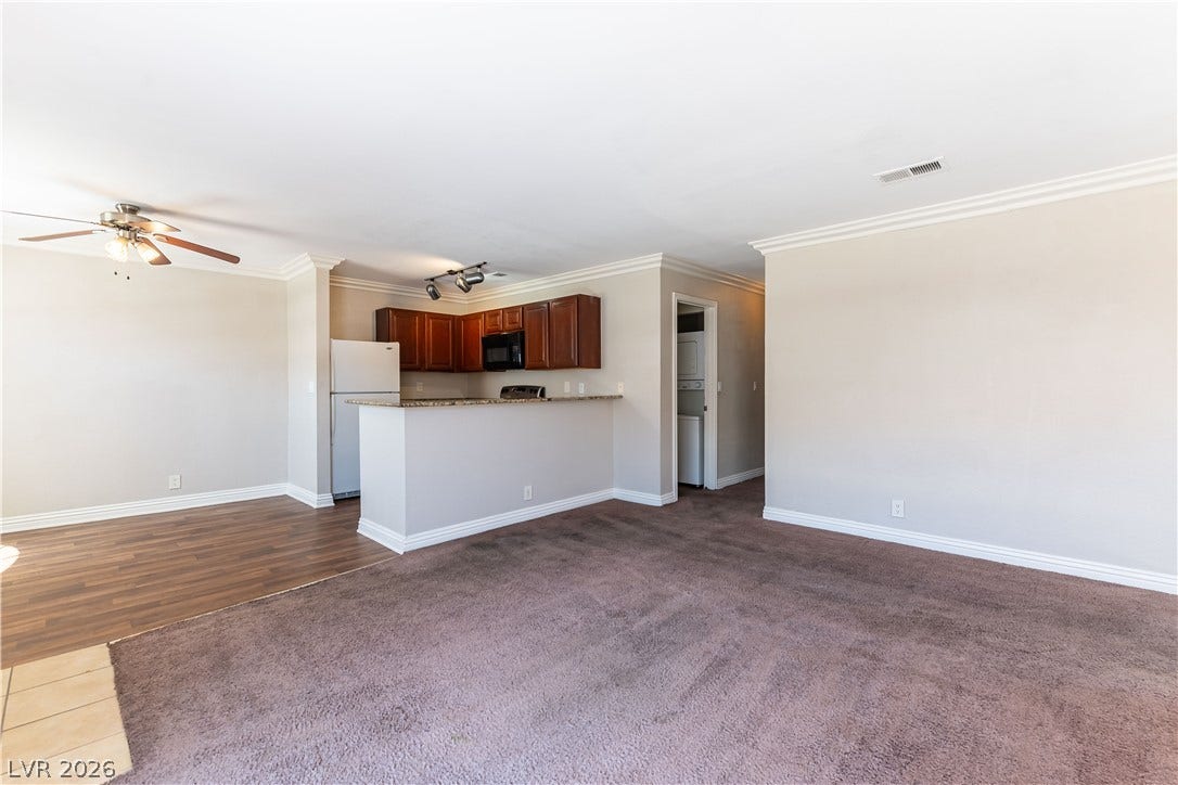 4050 Pacific Harbors Drive, #203, Las Vegas, NV 89121 Crisp crown molding highlights the transition from carpeted living spaces to the kitchen.