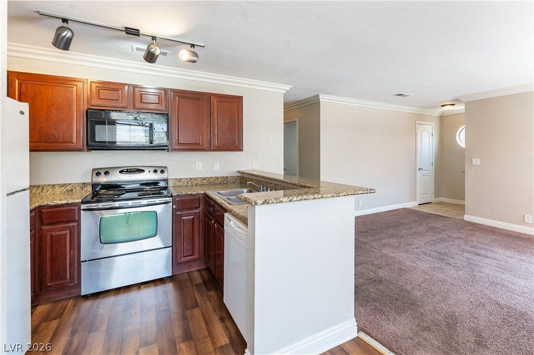 4050 Pacific Harbors Drive, #203, Las Vegas, NV 89121 Gleaming granite countertops accent this open floor plan layout connecting kitchen and living spaces.