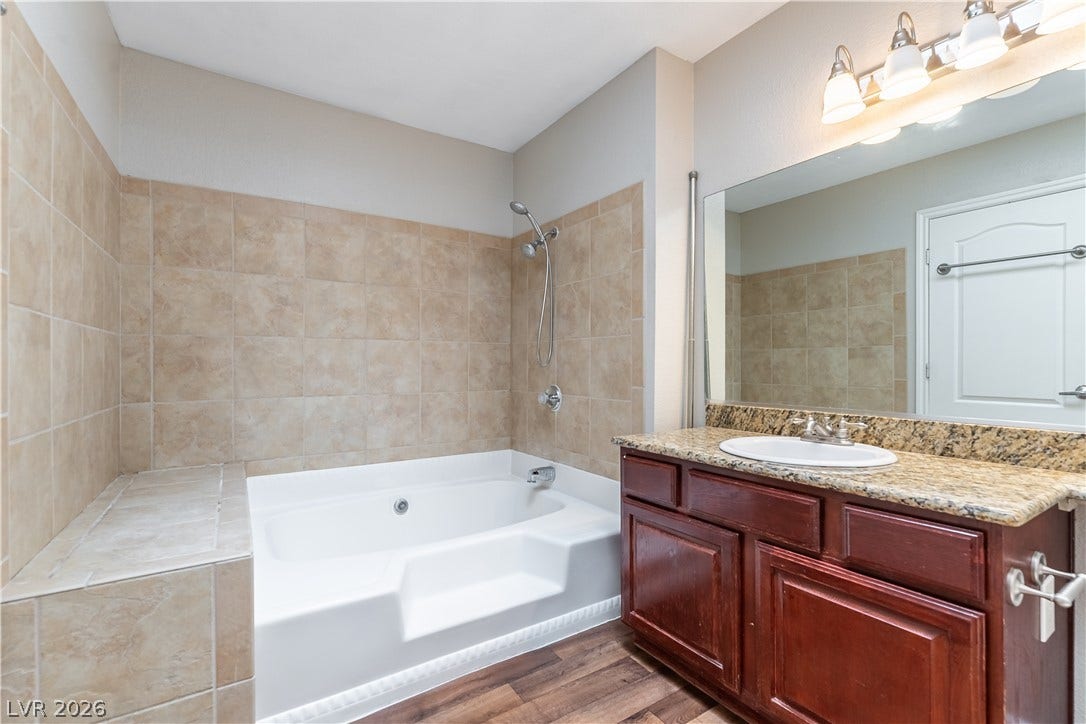 4050 Pacific Harbors Drive, #203, Las Vegas, NV 89121 Granite countertops and warm wall tiling elevate this comfortable bathroom space.