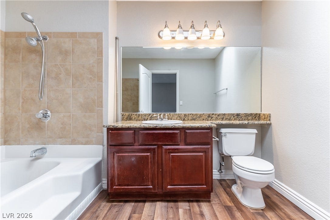 4050 Pacific Harbors Drive, #203, Las Vegas, NV 89121 A spacious vanity with stone countertops highlights this functional bathroom featuring a soaking tub.