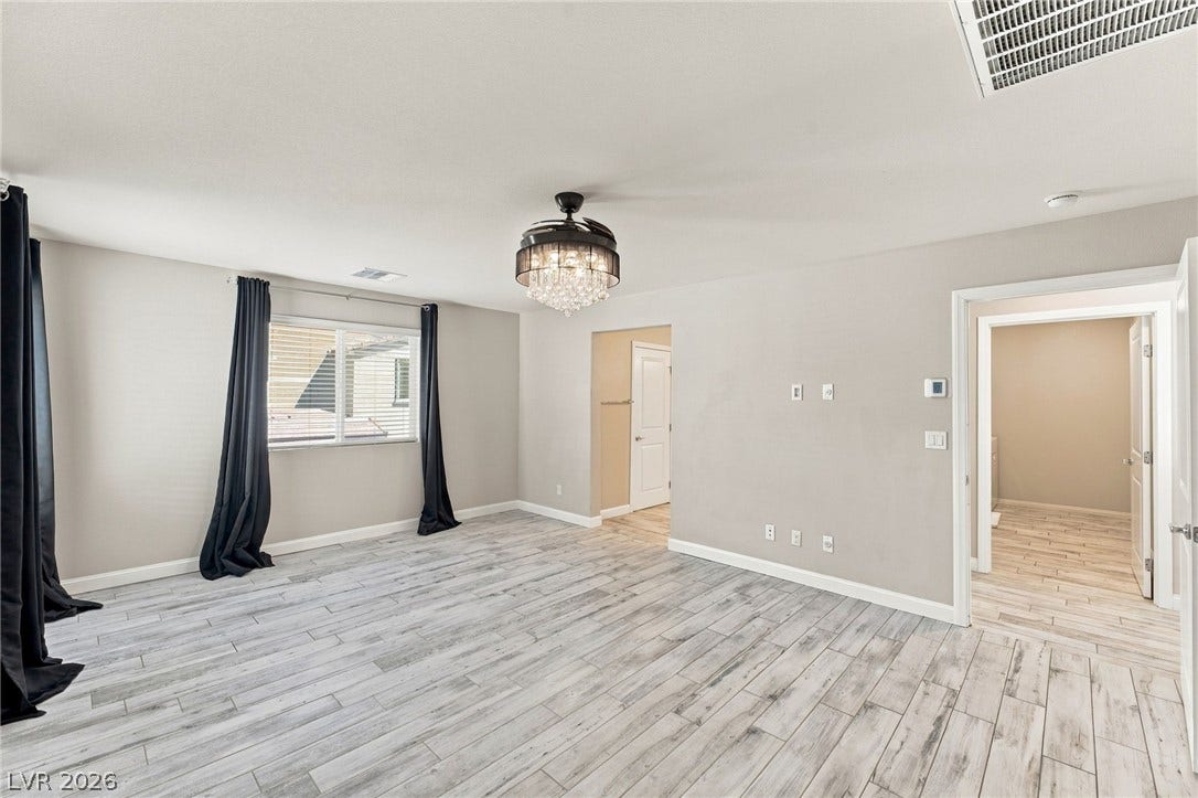 4216 Campriani Avenue, North Las Vegas, NV 89084 Plank-style flooring and natural light from wide windows define this versatile living space.