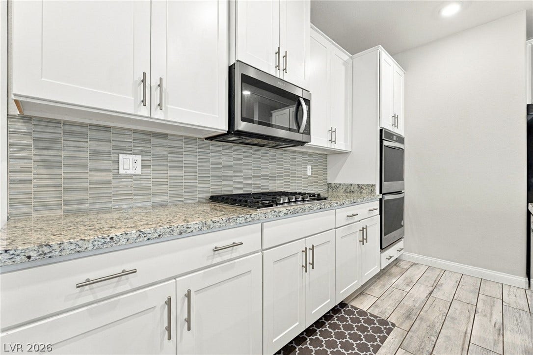 4216 Campriani Avenue, North Las Vegas, NV 89084 Polished granite countertops complement modern white cabinetry and premium stainless steel appliances.
