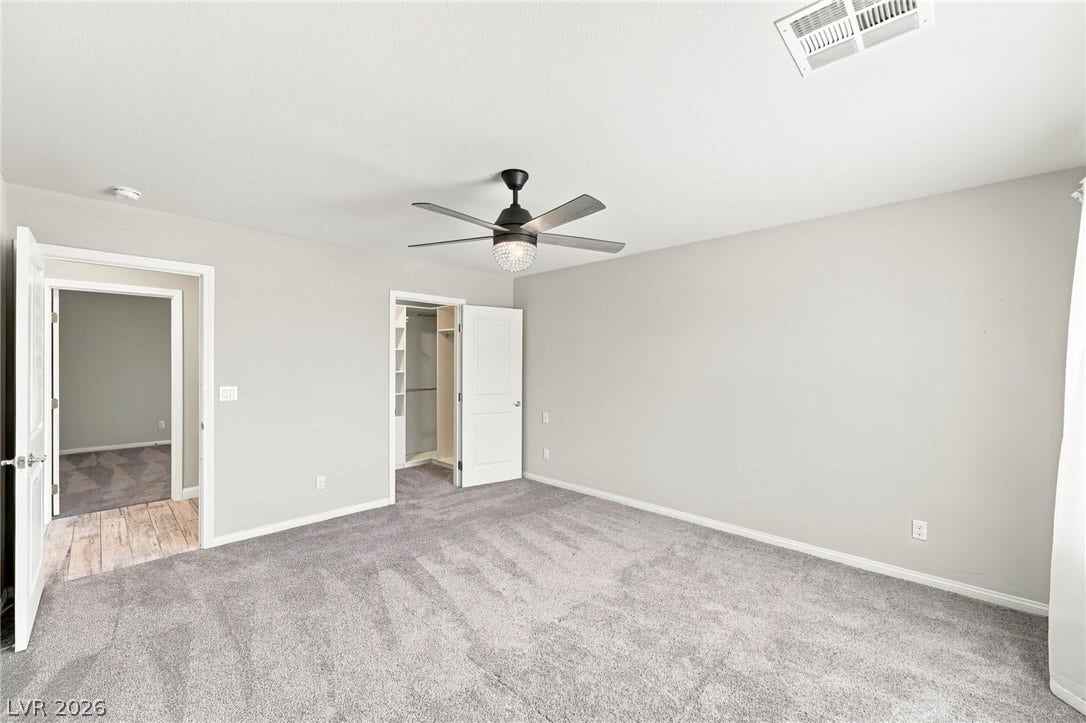 4216 Campriani Avenue, North Las Vegas, NV 89084 Plush carpeting and crisp white trim enhance this airy, versatile bedroom space.