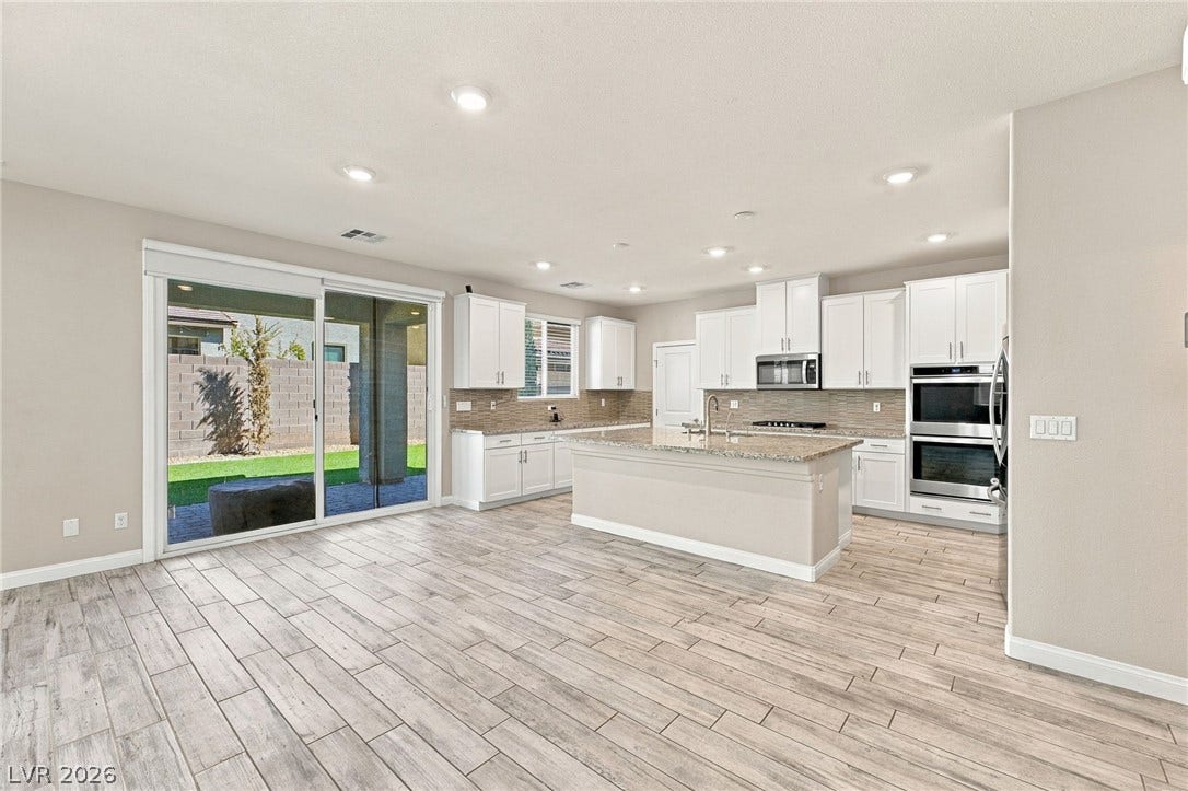 4216 Campriani Avenue, North Las Vegas, NV 89084 Gleaming wood-look tile floors connect a spacious living area to the modern kitchen.