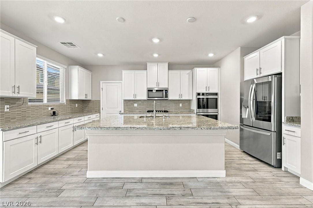 4216 Campriani Avenue, North Las Vegas, NV 89084 Gleaming stone countertops and matching cabinetry surround a generous central island.