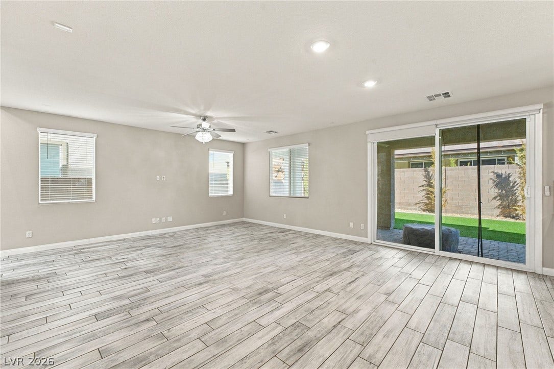 4216 Campriani Avenue, North Las Vegas, NV 89084 Sliding glass doors open directly to the backyard from this wood-look tile living space.