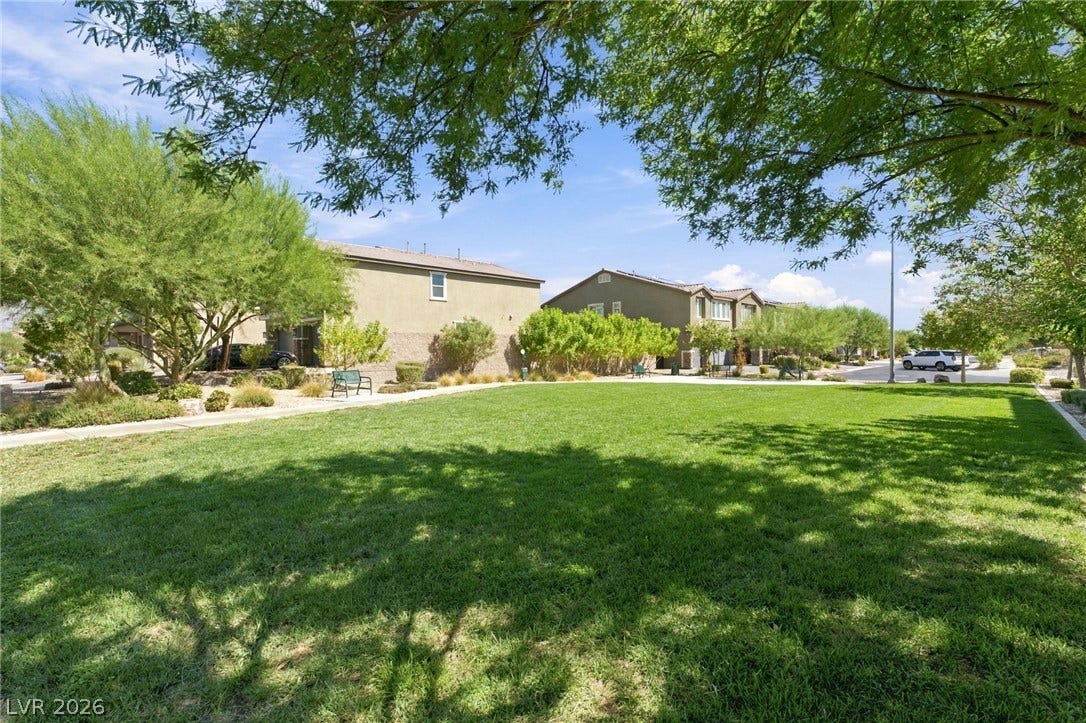 4216 Campriani Avenue, North Las Vegas, NV 89084 Mature trees shade a manicured common lawn area within a quiet residential neighborhood.