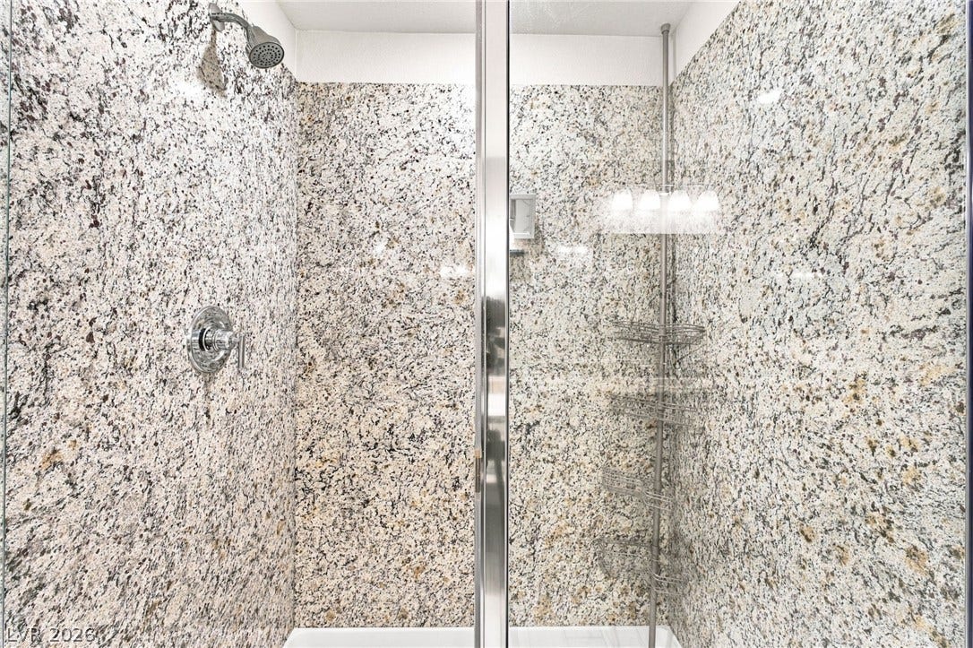 4216 Campriani Avenue, North Las Vegas, NV 89084 Glistening stone walls surround this pristine walk-in shower with a sleek glass enclosure.
