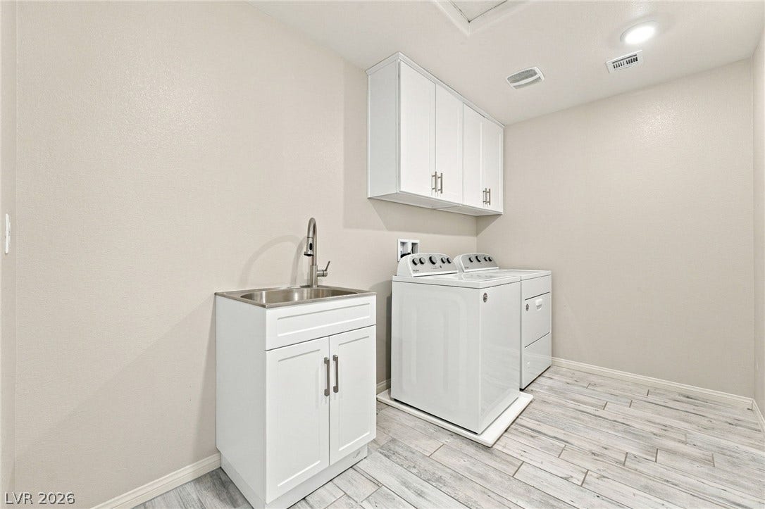 4216 Campriani Avenue, North Las Vegas, NV 89084 Functional laundry space showcases durable tile flooring alongside overhead cabinetry and a built-in sink.