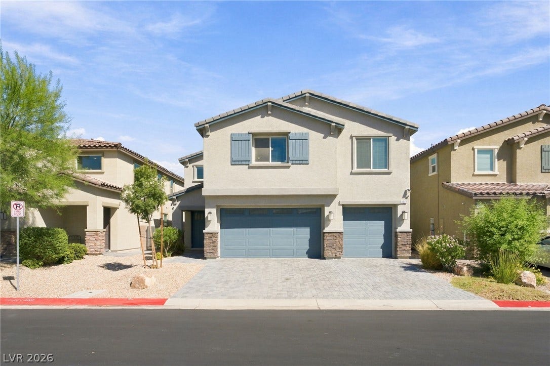 4216 Campriani Avenue, North Las Vegas, NV 89084 A paved driveway leads to a modern two-story exterior featuring stone accents and decorative shutters.