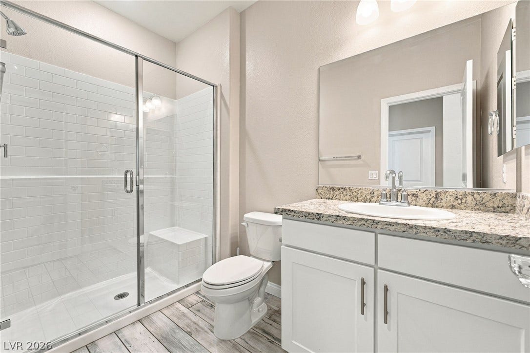 4216 Campriani Avenue, North Las Vegas, NV 89084 Granite counters and a tiled walk-in shower elevate this updated bathroom space.