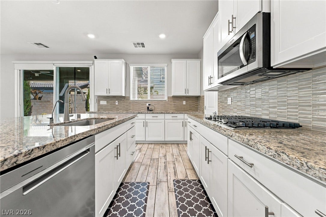 4216 Campriani Avenue, North Las Vegas, NV 89084 Polished granite countertops and classic white cabinetry define this bright cooking space.