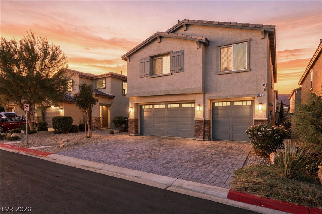 4216 Campriani Avenue, North Las Vegas, NV 89084 A paved driveway leads to the multi-car garage of this multi-level home under sunset skies.