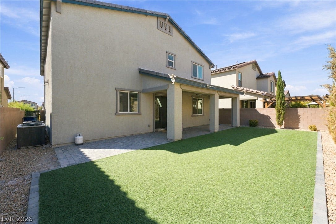 4216 Campriani Avenue, North Las Vegas, NV 89084 A covered patio overlooks a manicured green lawn framed by clean block wall fencing.