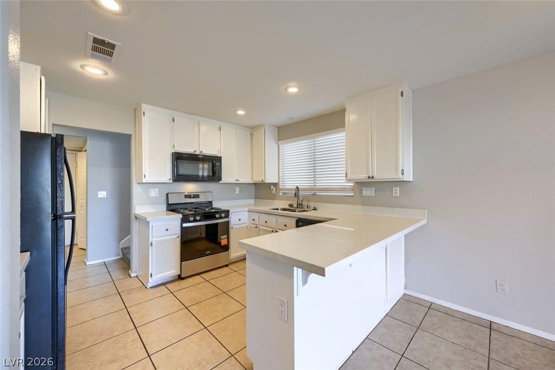 6027 Dawn View Lane, North Las Vegas, NV 89031 Ample counter space and classic cabinetry define this functional kitchen workspace.