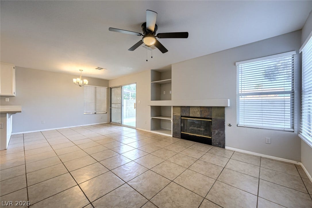 6027 Dawn View Lane, North Las Vegas, NV 89031 Tile flooring spans this open living space featuring a fireplace flanked by built-in shelving.