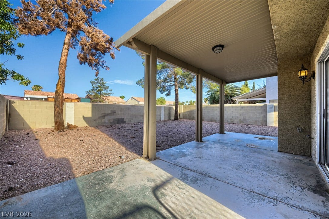 6027 Dawn View Lane, North Las Vegas, NV 89031 A sheltered concrete patio overlooks a low-maintenance backyard enclosed by block fencing.