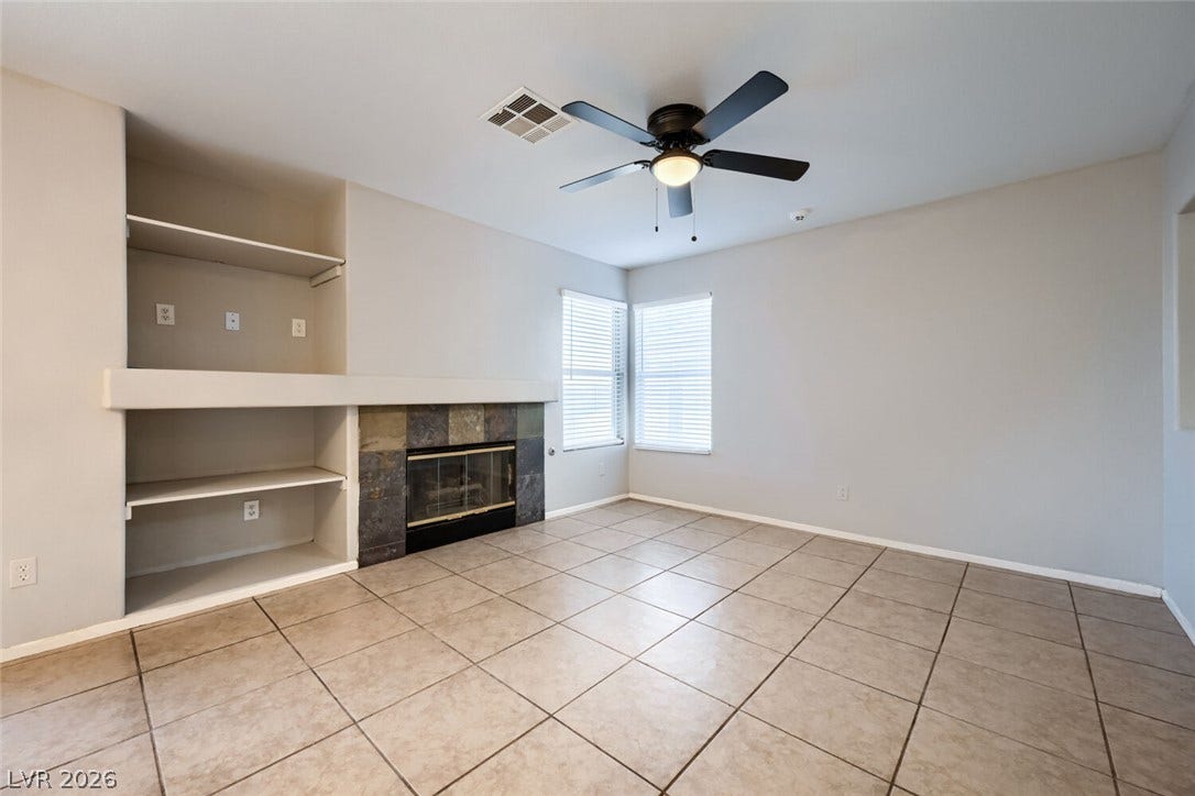 6027 Dawn View Lane, North Las Vegas, NV 89031 Tiled flooring and a stone fireplace create a welcoming focal point in this living area.