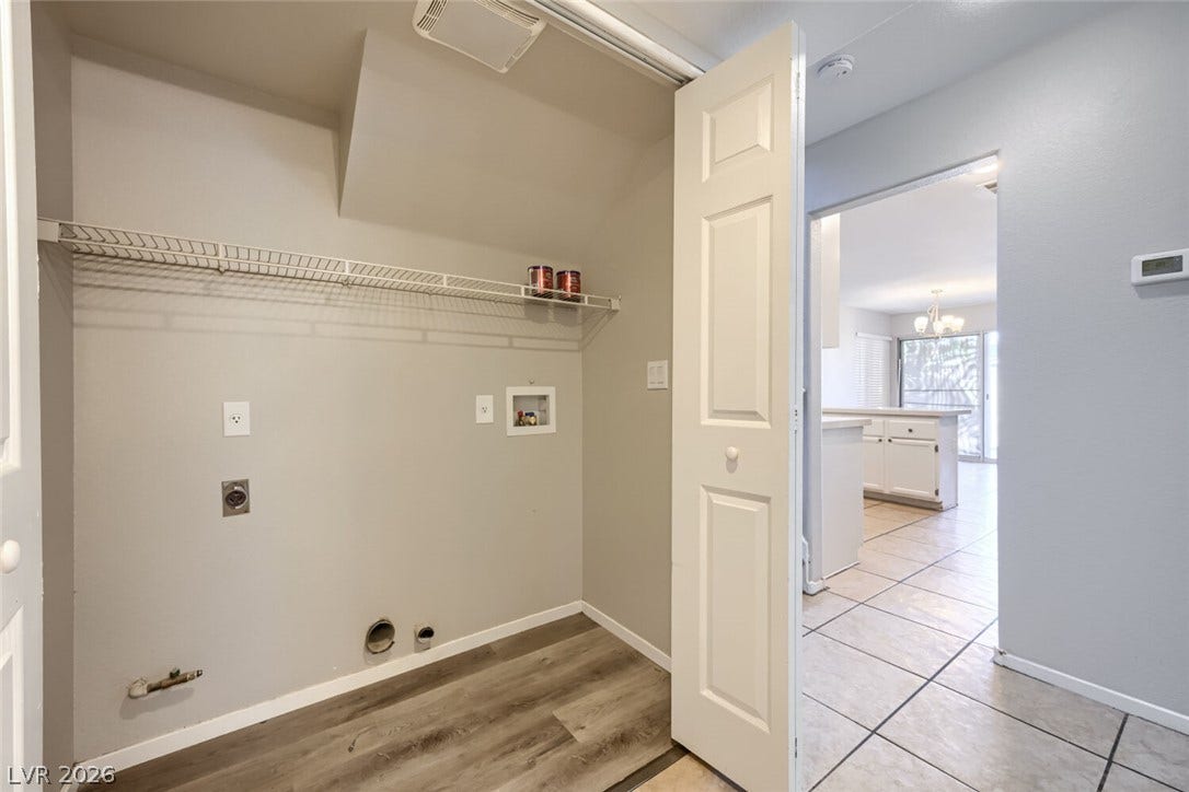 6027 Dawn View Lane, North Las Vegas, NV 89031 A dedicated laundry closet features wire shelving and convenient hookups off the tiled hallway.