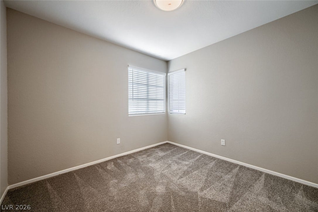 6027 Dawn View Lane, North Las Vegas, NV 89031 Plush carpeting and dual corner windows anchor this quiet, versatile bedroom space.