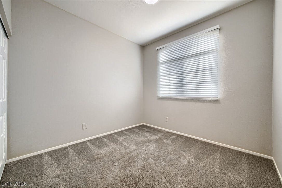 6027 Dawn View Lane, North Las Vegas, NV 89031 Plush carpeting and a large window define this versatile secondary bedroom space.