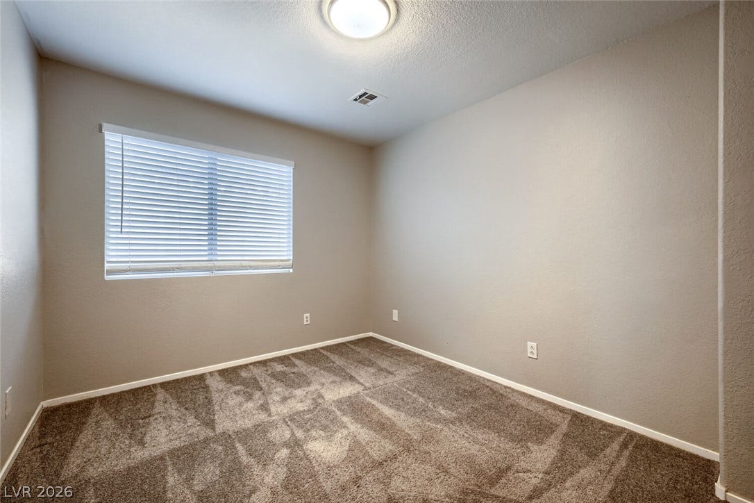 6027 Dawn View Lane, North Las Vegas, NV 89031 Soft carpeting underfoot and a wide window create a comfortable and inviting atmosphere.
