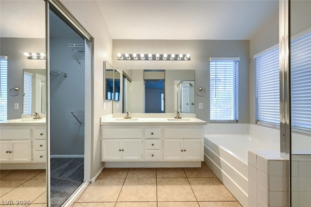 6027 Dawn View Lane, North Las Vegas, NV 89031 Tile flooring pairs with a dual-sink vanity and an integrated soaking tub.