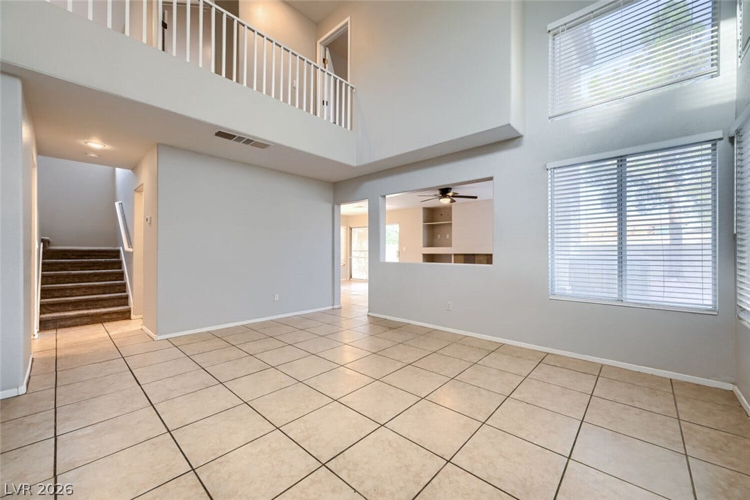 6027 Dawn View Lane, North Las Vegas, NV 89031 Tiled floors and soaring double-height ceilings define this open and airy living area.