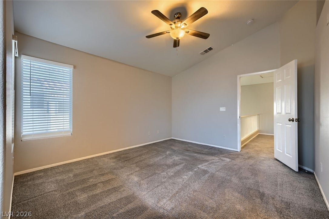 6027 Dawn View Lane, North Las Vegas, NV 89031 Plush carpeting and vaulted ceilings enhance this serene, light-filled bedroom design.