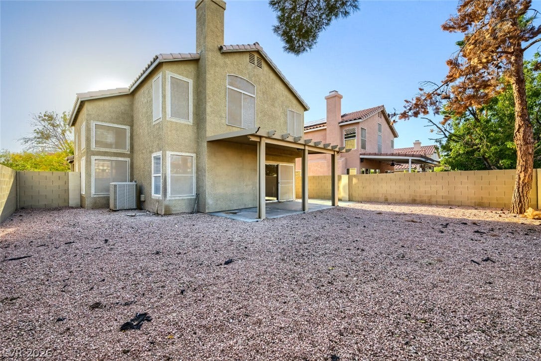 6027 Dawn View Lane, North Las Vegas, NV 89031 A spacious gravel yard sits behind this two-story home featuring a covered patio area.