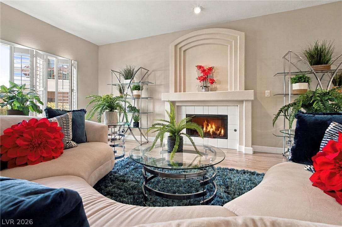 A classic fireplace with tiled trim anchors this comfortable living area featuring wood floors.