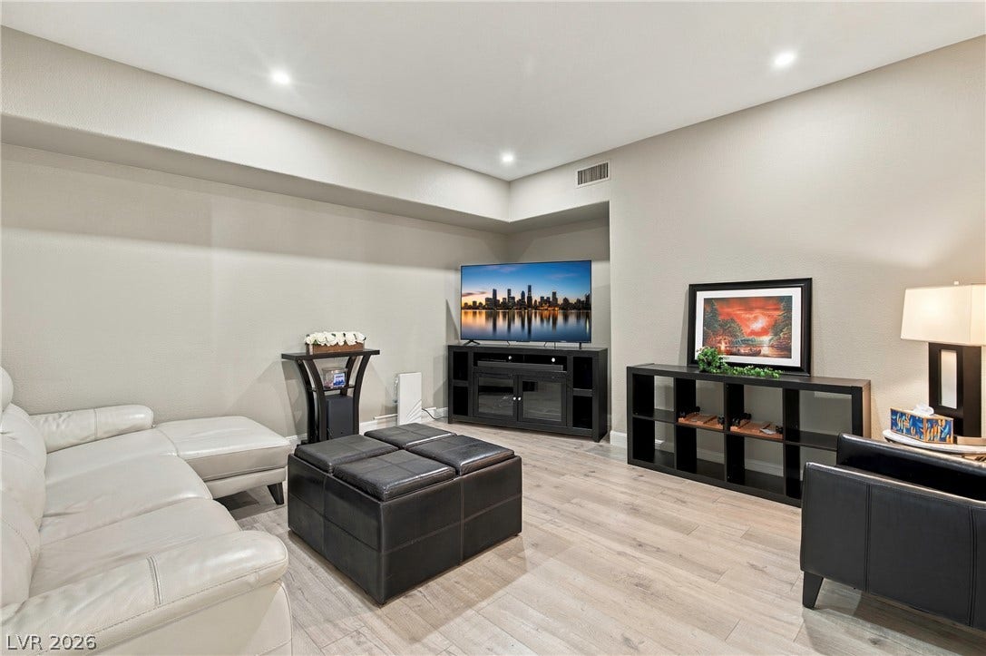 Recessed lighting illuminates the smooth wood floors of this versatile media space.
