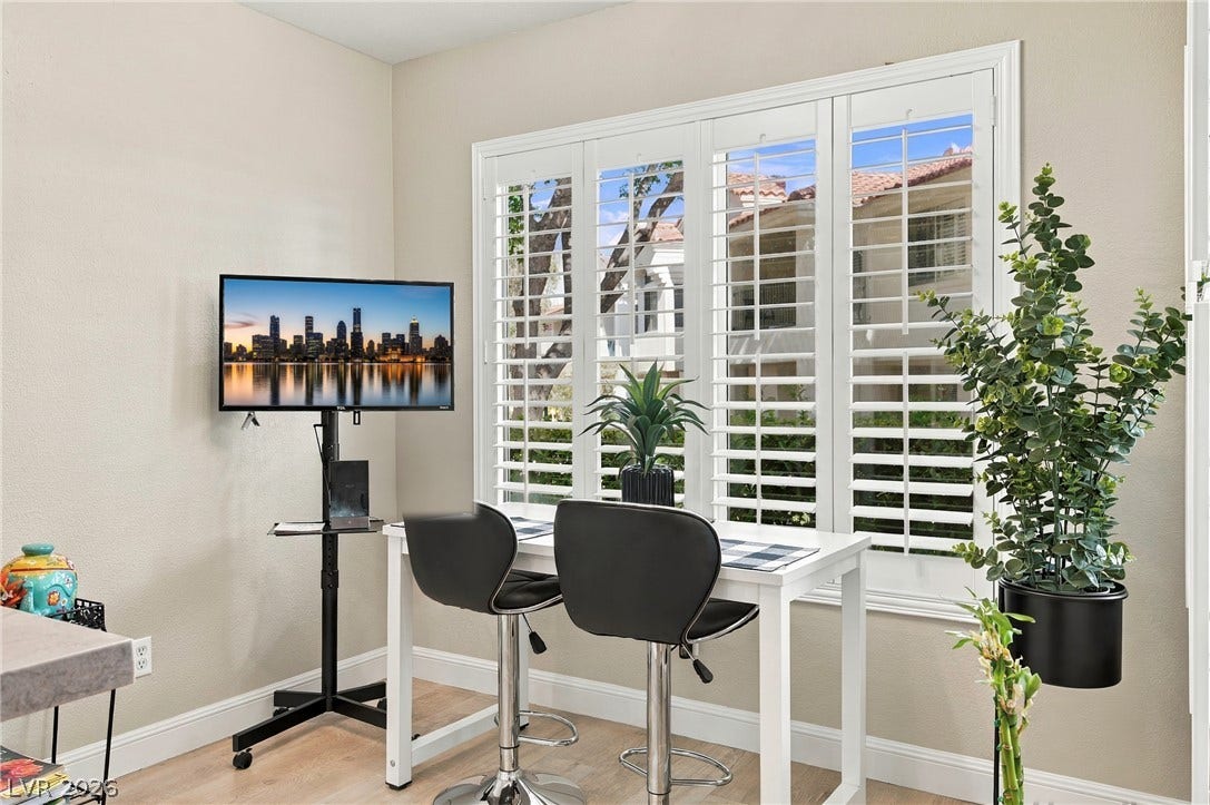 Gleaming wood floors anchor this versatile space illuminated by a large window with plantation shutters.