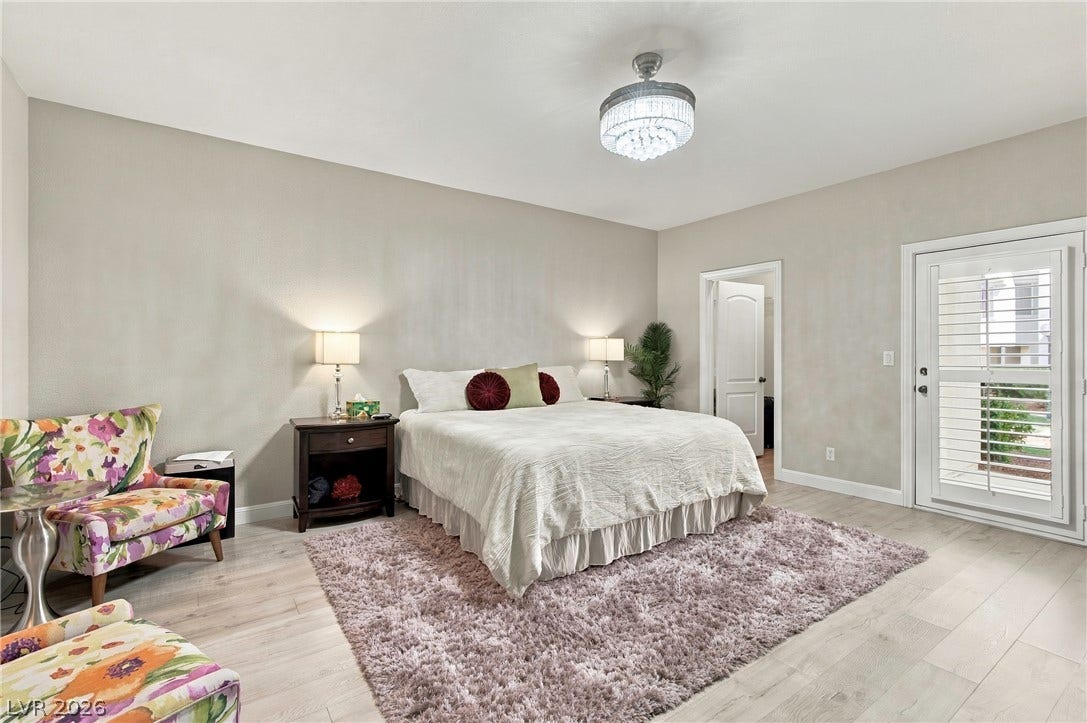 Primary bedroom with two walk-in closets and patio access.