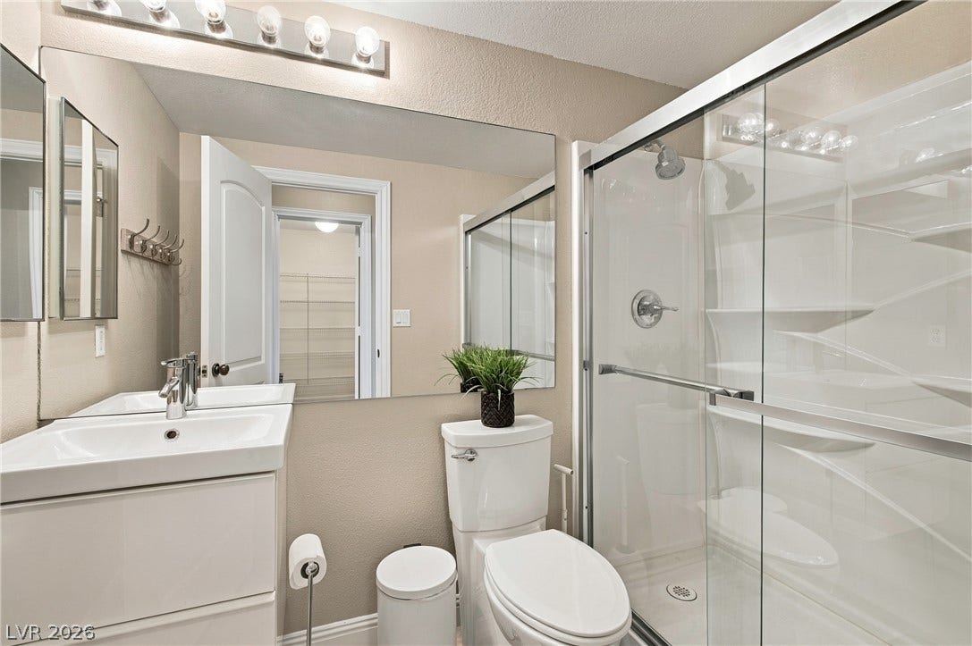 A glass-enclosed walk-in shower pairs with a clean vanity in this modern bathroom.