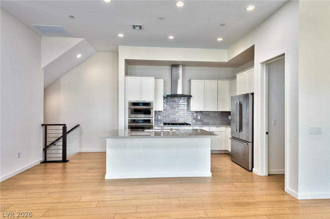3327 Esker Ridge Avenue, Henderson, NV 89044 Clean lines and a spacious island define this modern culinary workspace with warm wood flooring.