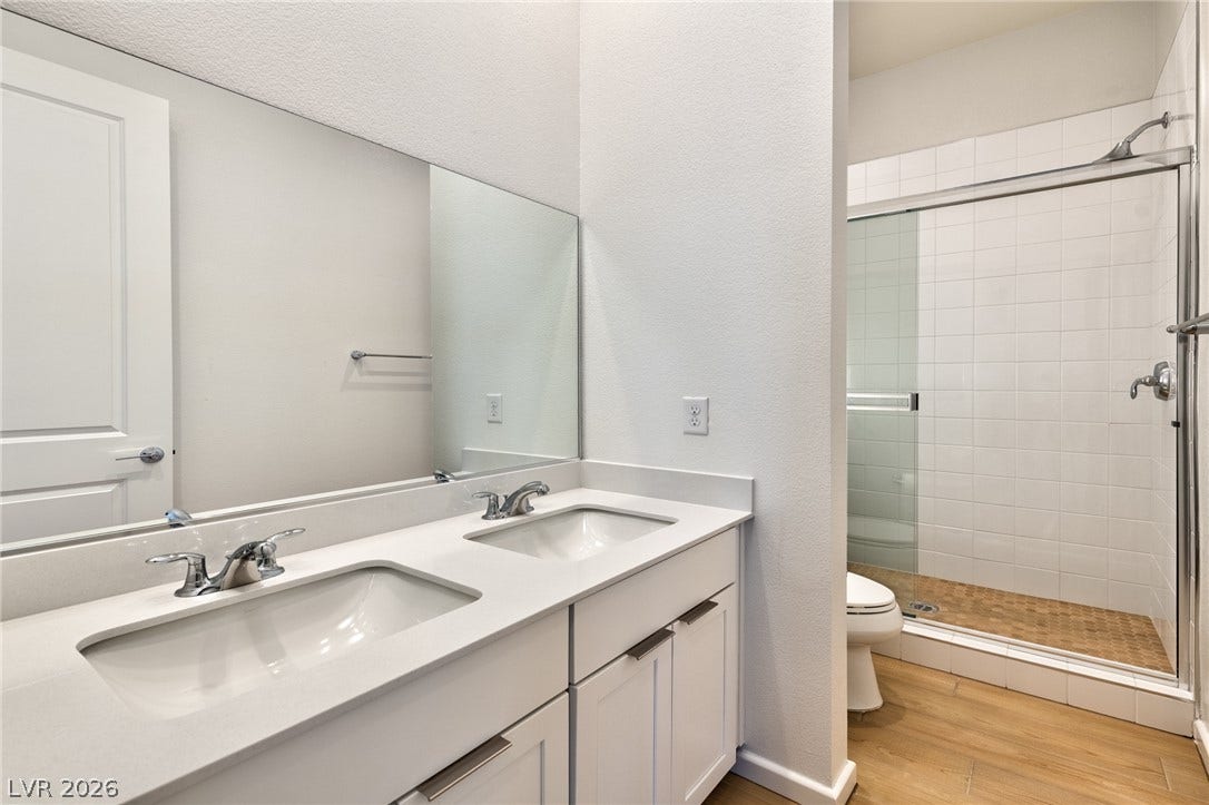 3327 Esker Ridge Avenue, Henderson, NV 89044 Clean lines and a spacious dual vanity define this modern bathroom with a walk-in shower.