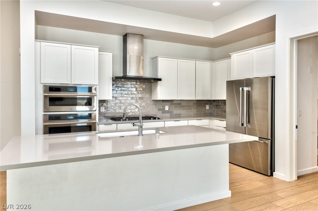 3327 Esker Ridge Avenue, Henderson, NV 89044 Sleek quartz countertops and professional-grade stainless steel appliances anchor this modern culinary workspace.