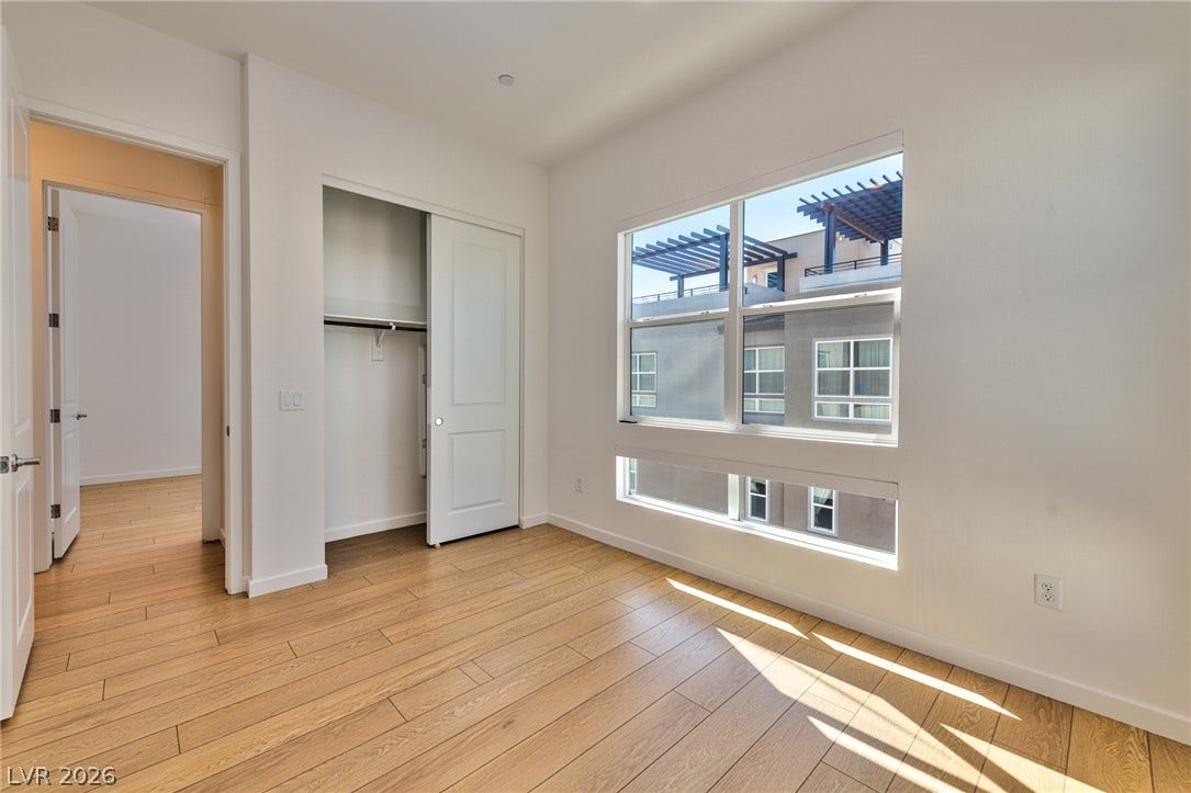 3327 Esker Ridge Avenue, Henderson, NV 89044 Natural sunlight filters across the warm wood floors of this modern, minimalist bedroom.
