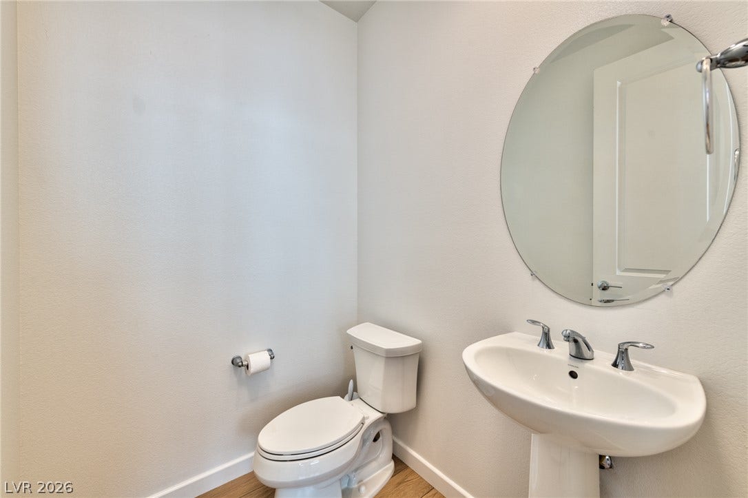 3327 Esker Ridge Avenue, Henderson, NV 89044 A classic pedestal sink paired with an oval wall mirror enhances this neat half bath.