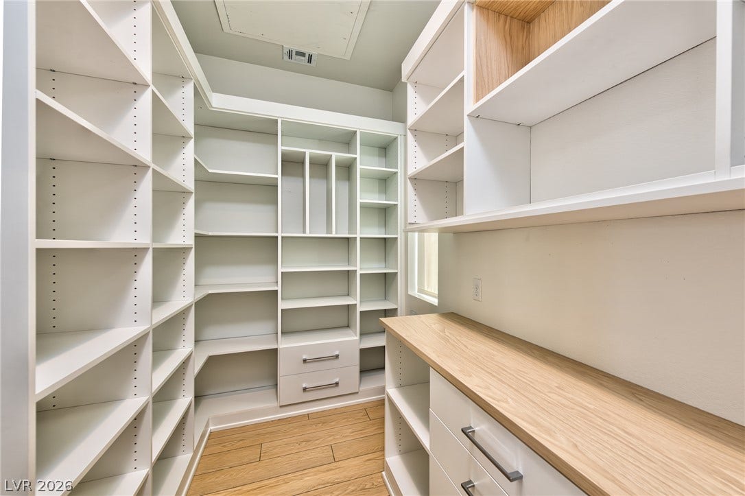3327 Esker Ridge Avenue, Henderson, NV 89044 Custom built-in shelving and wood-look flooring maximize storage in this walk-in closet.