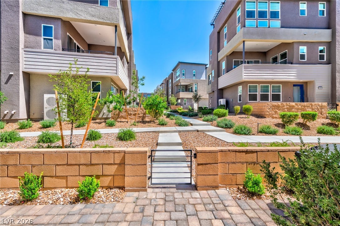 3327 Esker Ridge Avenue, Henderson, NV 89044 Concrete walkways wind through meticulously landscaped grounds bordered by modern multi-level townhomes.